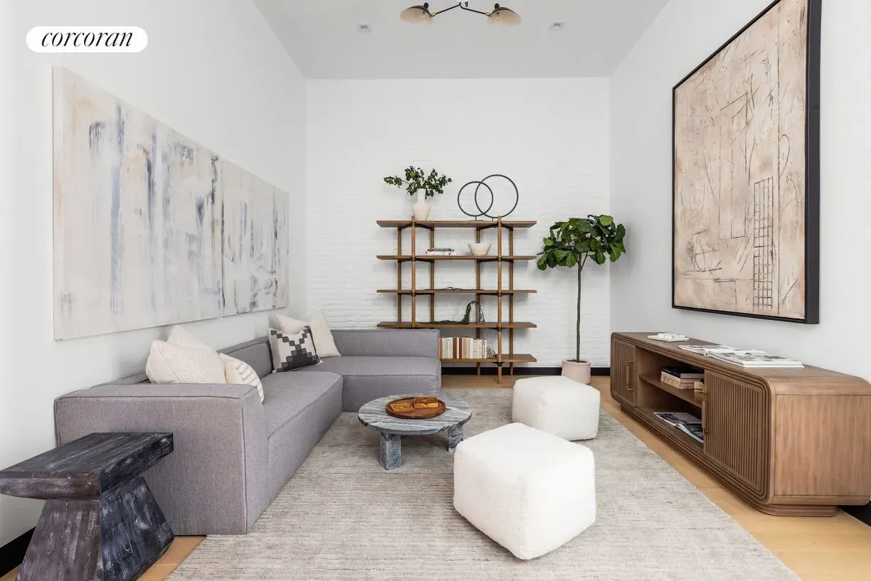 Sleek sectional, sculptural table, soft palette. Calm but not boring.