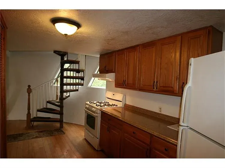 Okay, this kitchen—honey cabinets, angled window flooding light. Not sure about the slick counters.