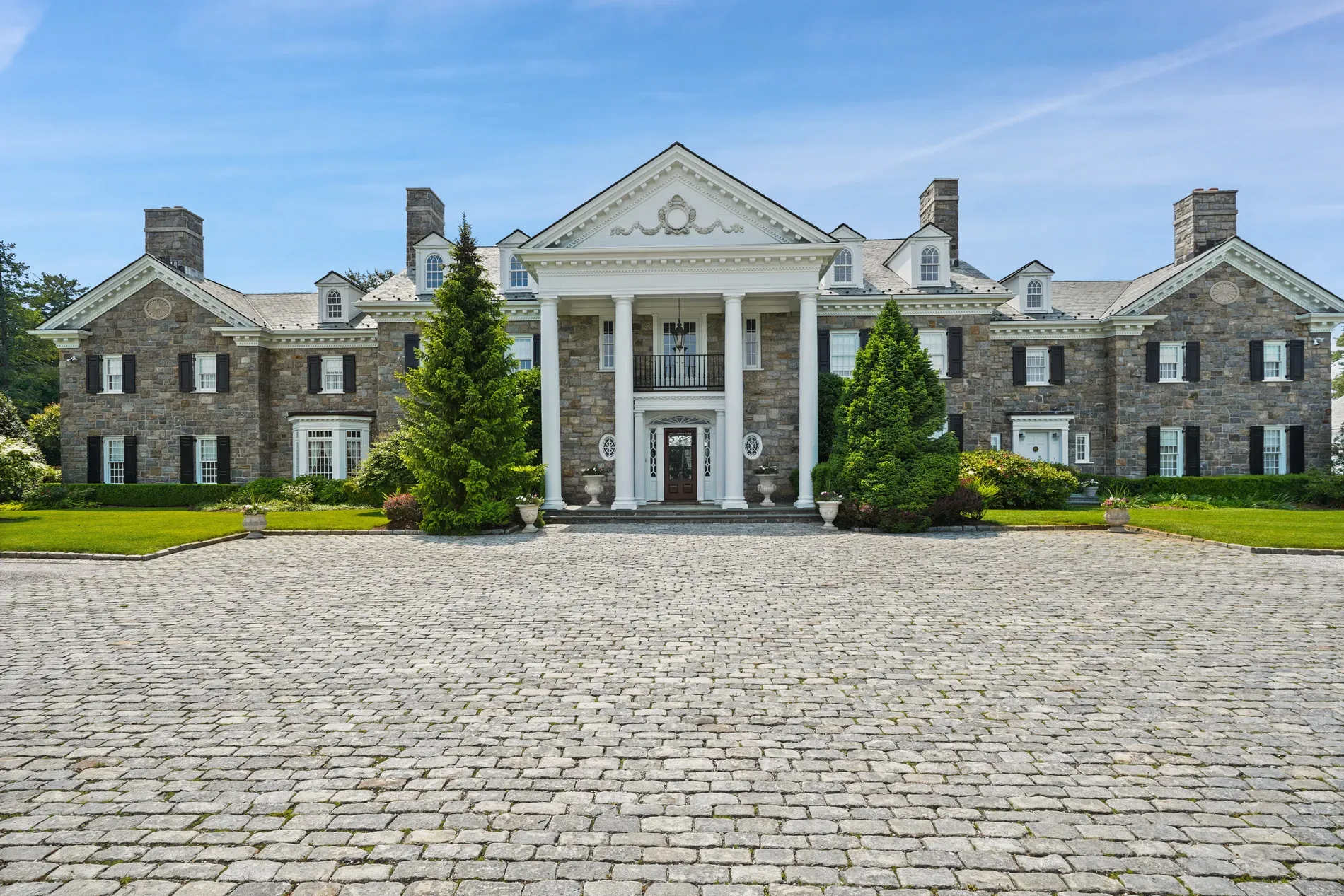 Here's the front — gray stone, crisp white, big pediment and those drama columns.