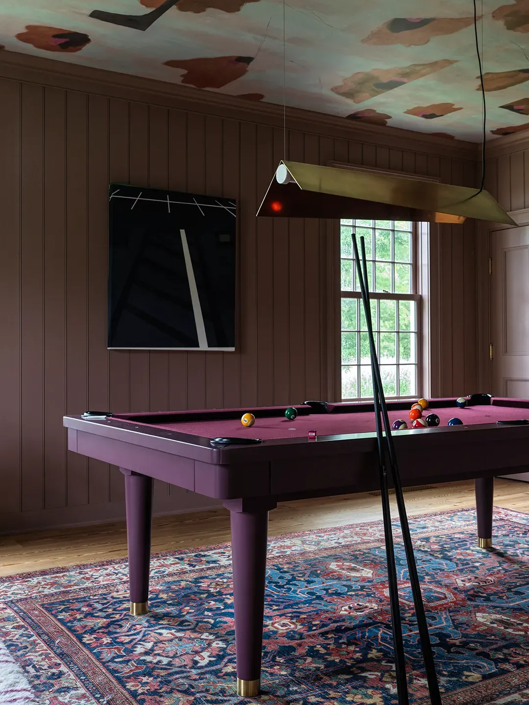 Game room wins—burgundy felt, black cues. From this angle, looks tournament ready.
