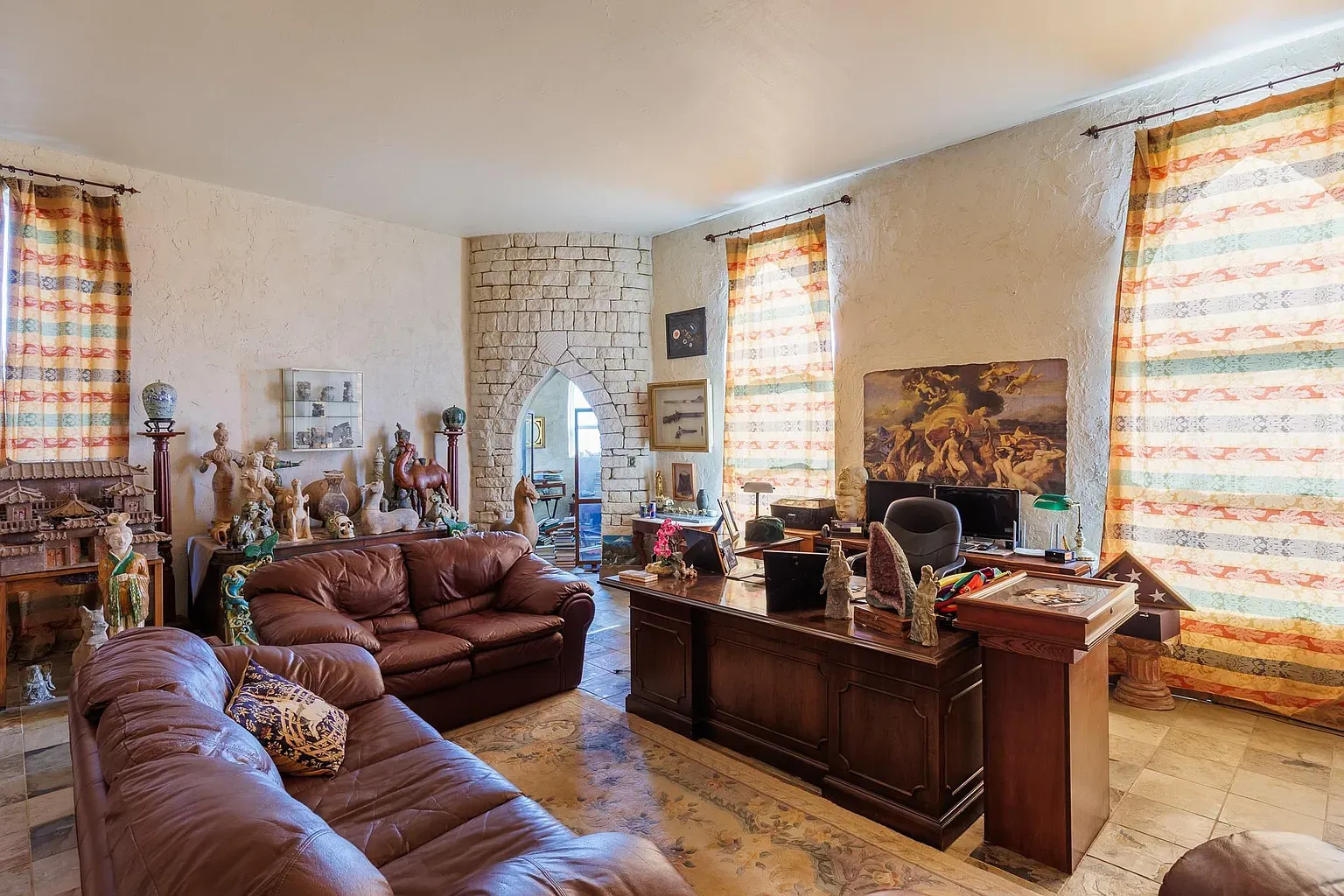 Arched stone fireplace steals it. Rest of the room feels collected over years.