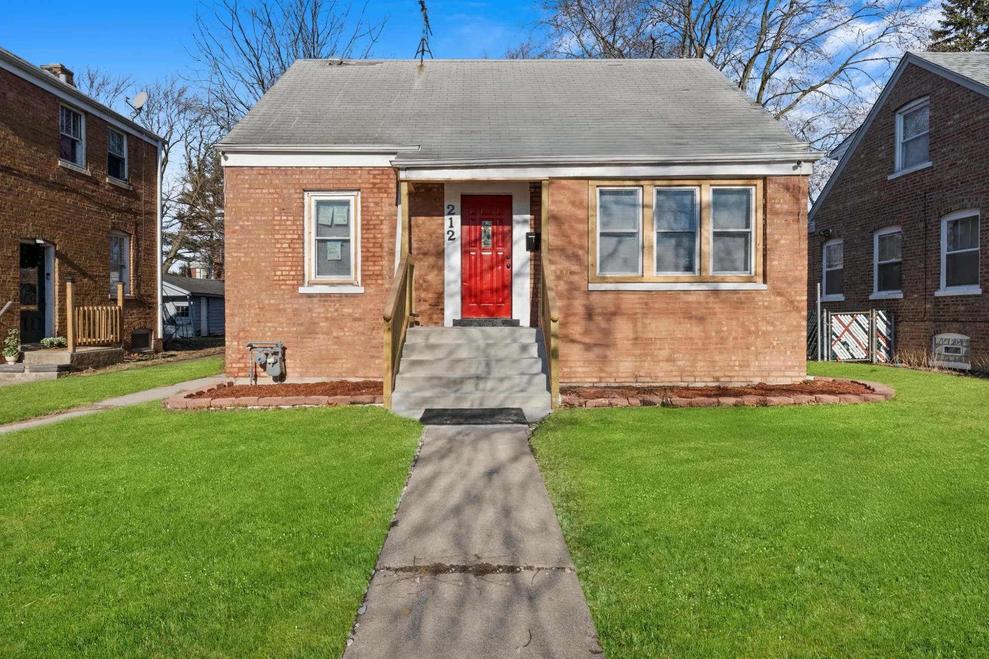 Here’s the exterior—warm brick, grey gable. Pretty cozy. That central entry pops.