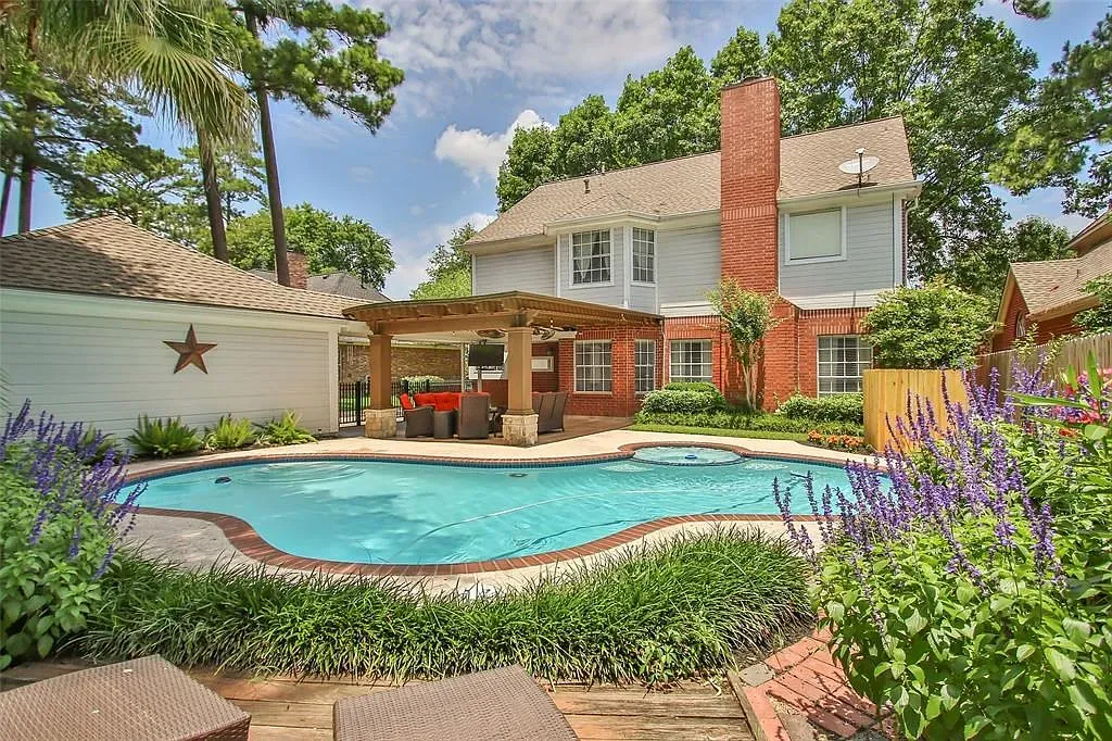 Curvy blue pool wrapped in warm wood. I’d spend summers right here.