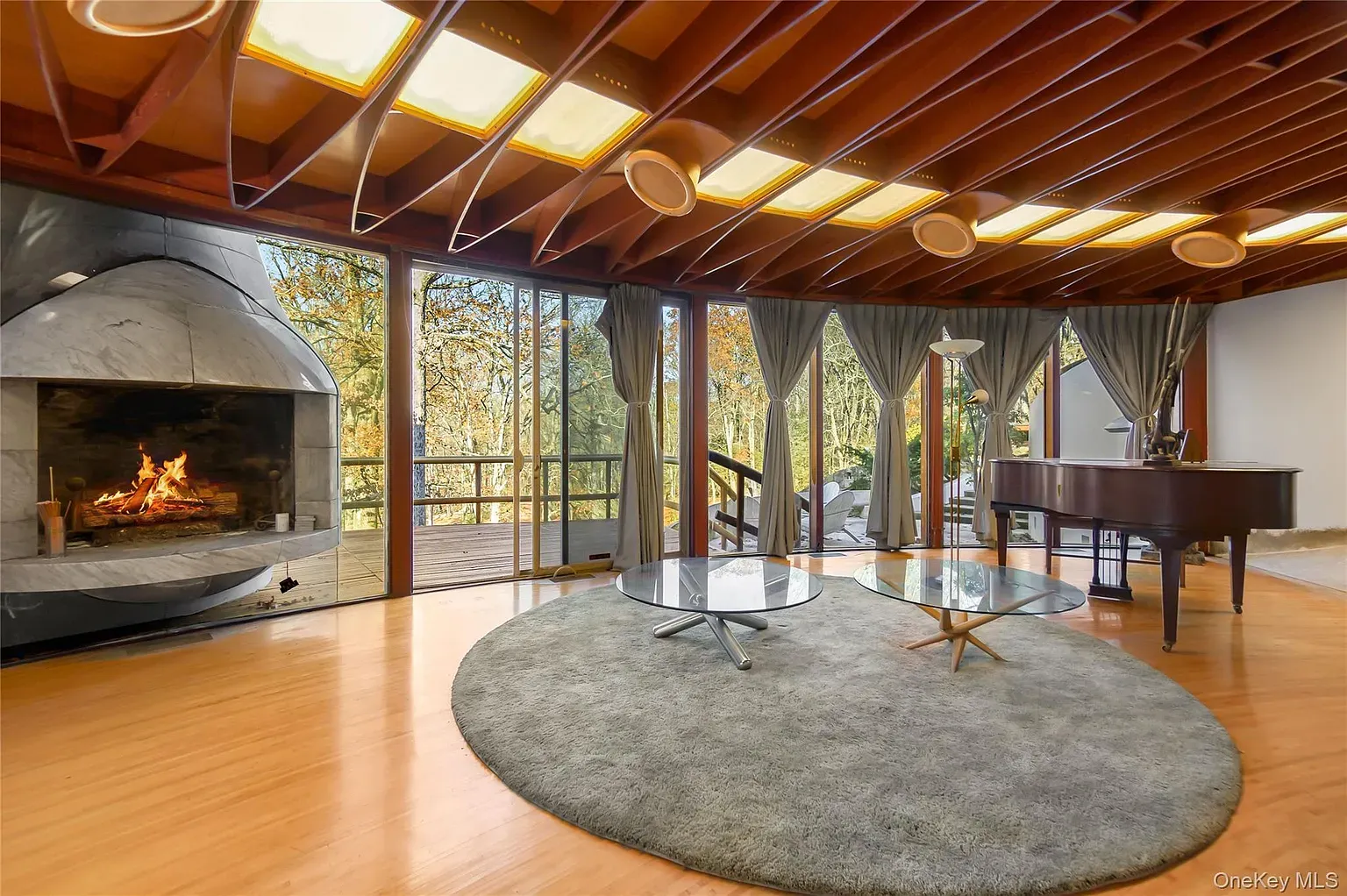 Curved stone fireplace steals the room. Looks warm without trying.