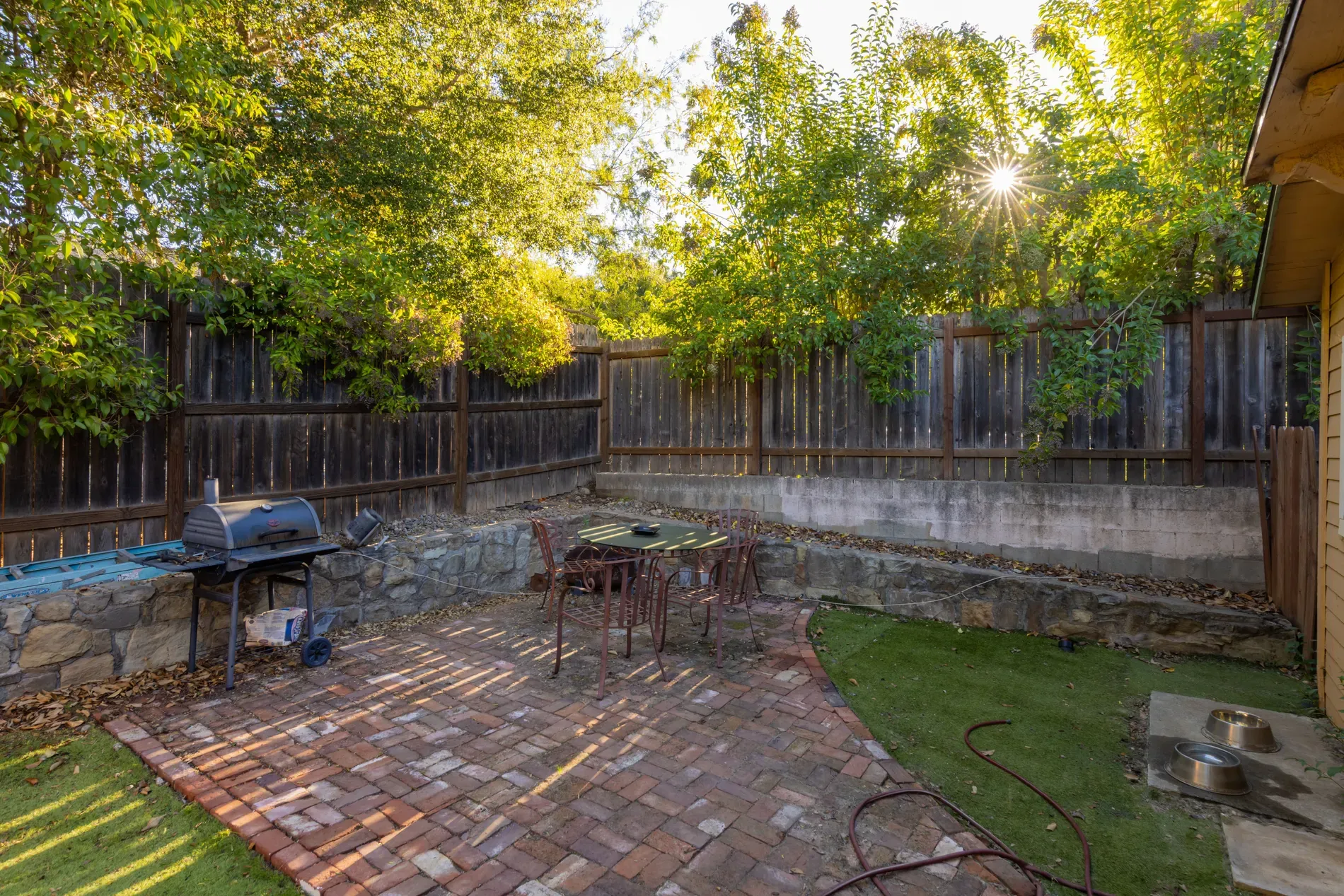 Herringbone brick patio and low stone edging. Feels cozy.