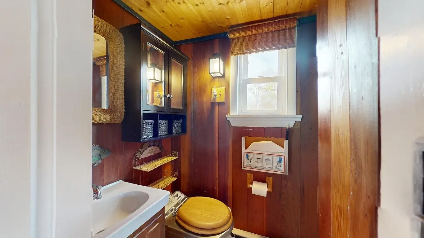 Rustic bathroom with dark wood walls. Looks snug and surprisingly polished.