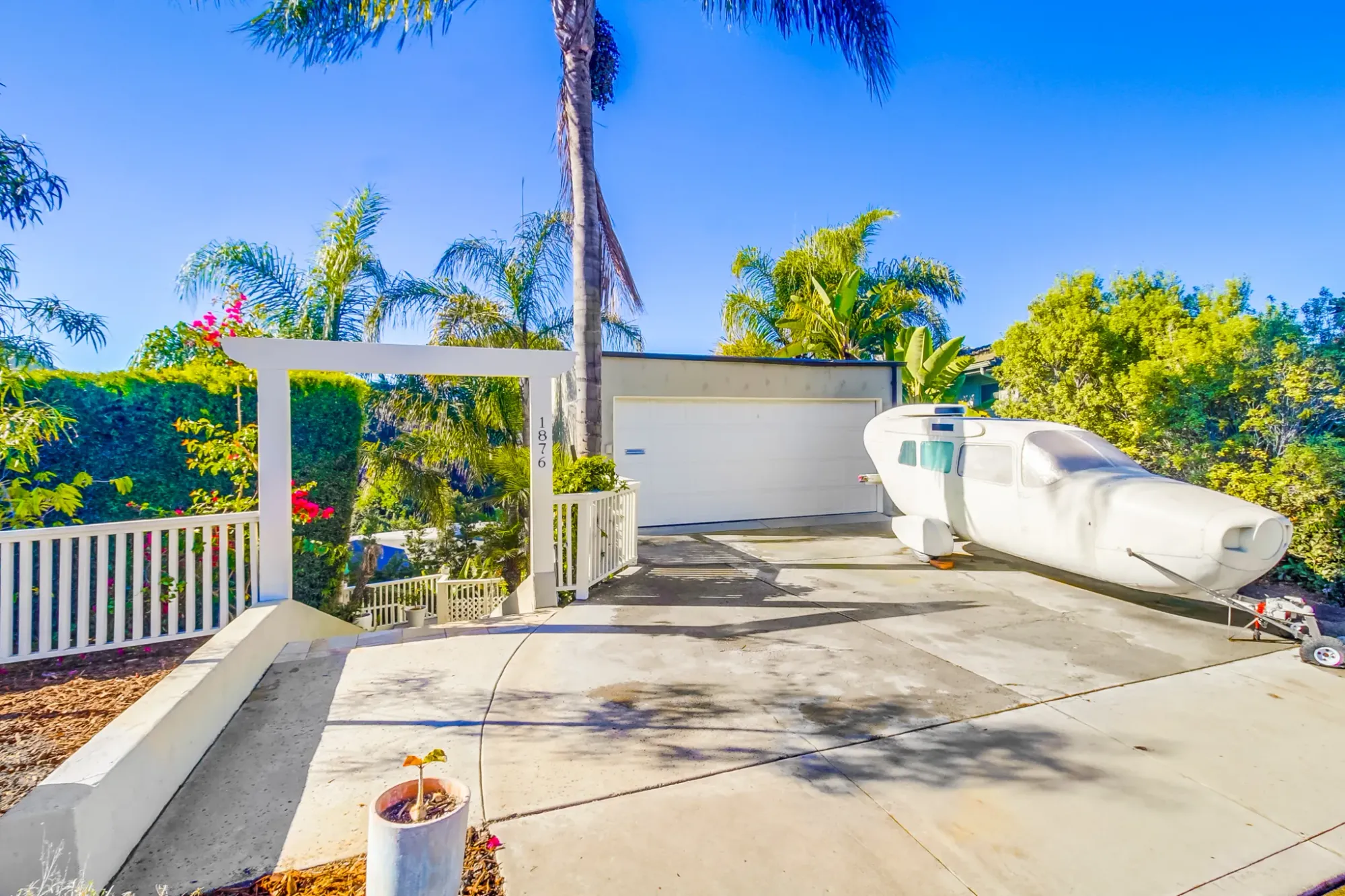 Modern exterior, clean lines, big driveway, and an airplane-shaped thing out front.