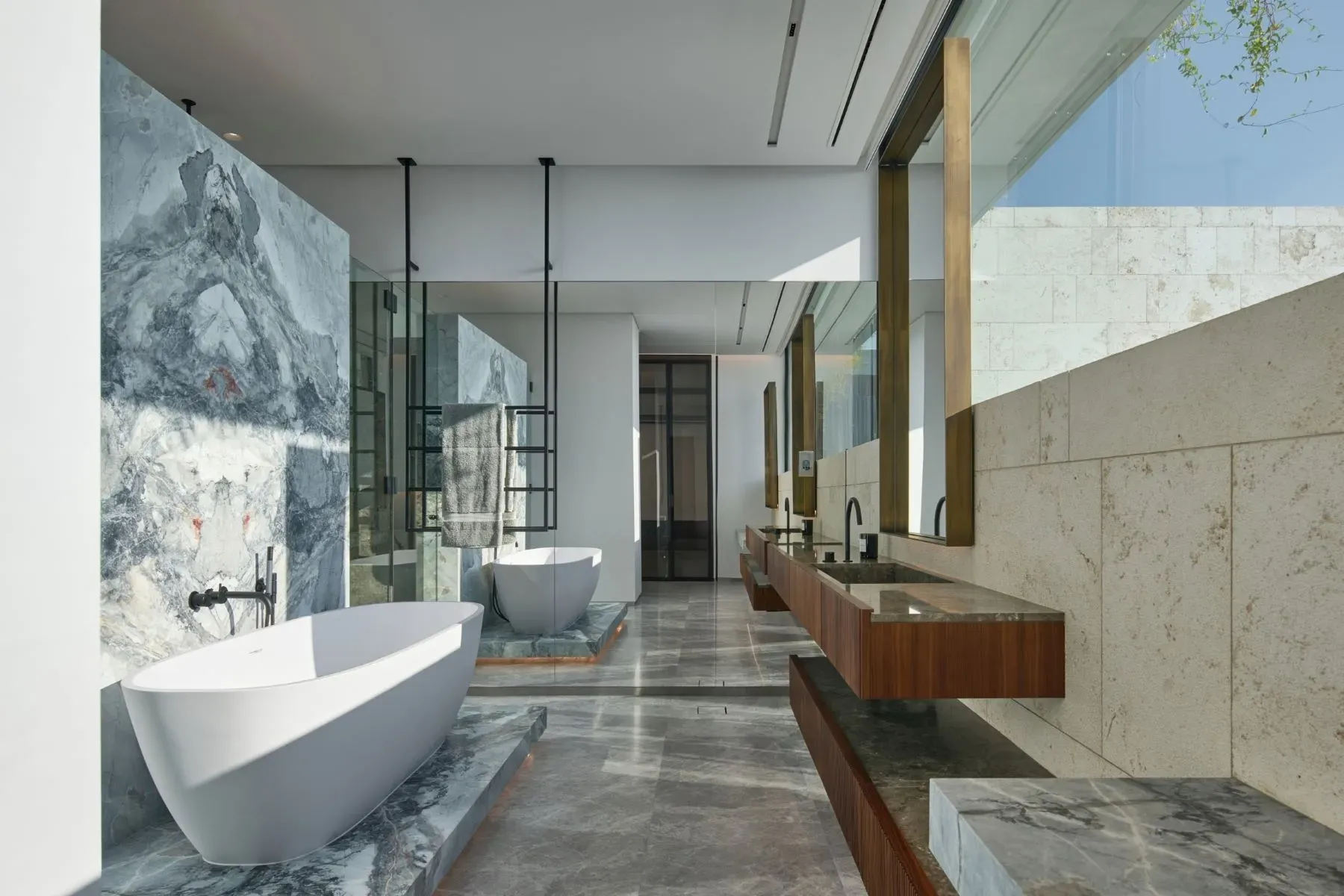 Bathroom marble looks a storm cloud. Minimal fixtures, huge slabs.