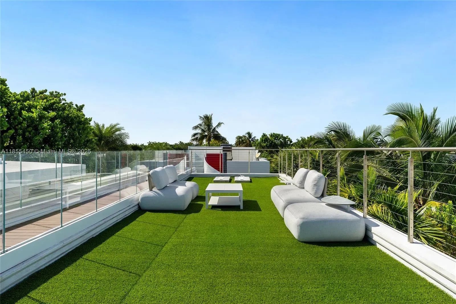 Rooftop lawn with plush gray sofas. Fake grass—not sure, but cozy.