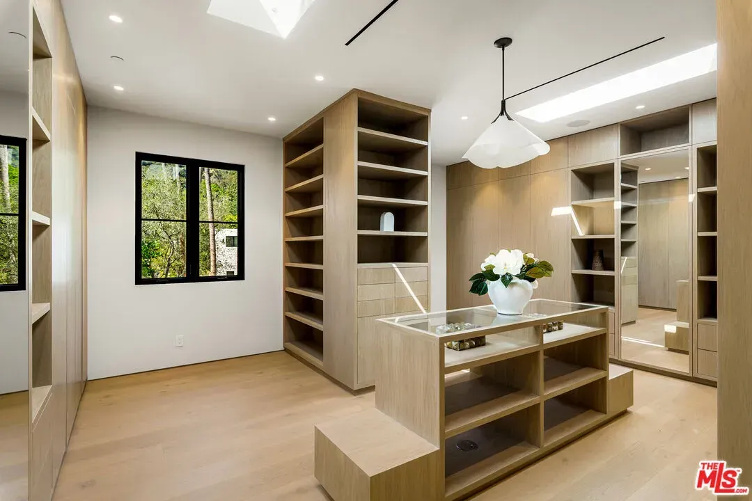 Minimalist room, warm white walls, honey floors. Calm without trying.