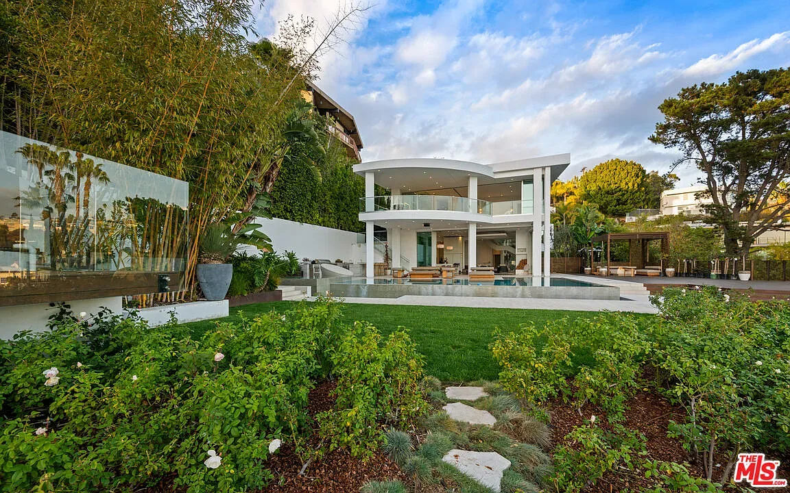 That curved white exterior is wild. Floor-to-ceiling glass everywhere.