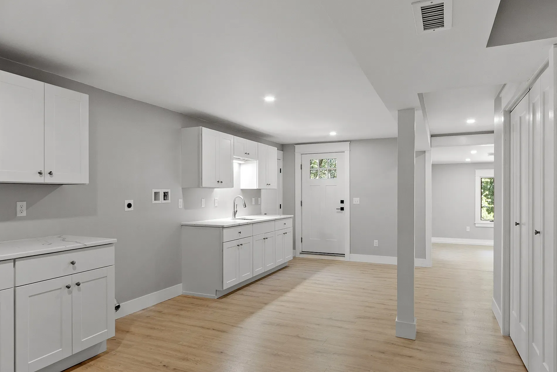 Open layout spilling into the kitchen. everything in that soft neutral gray.