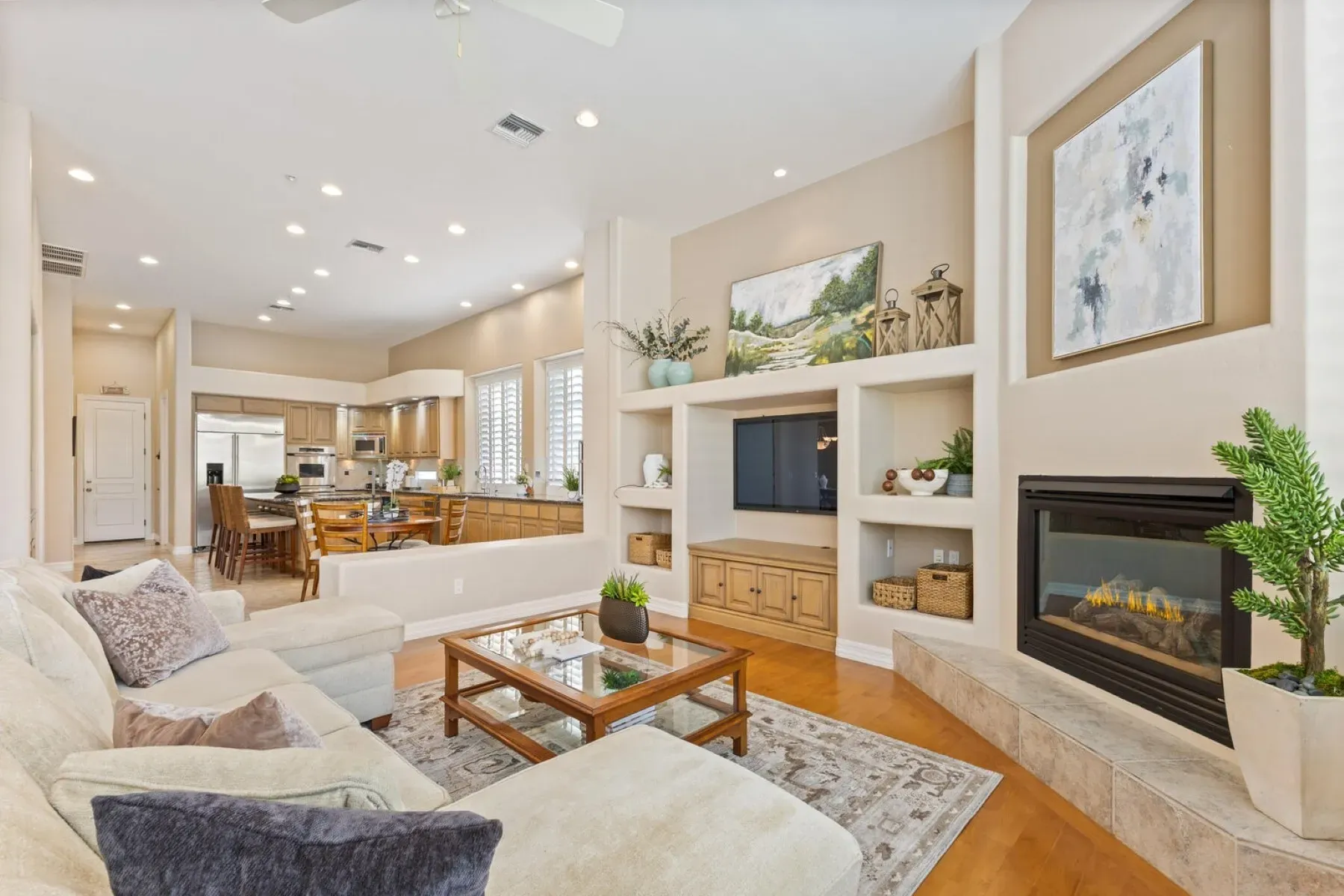Cream L-shaped sofa under warm beige walls. Cozy TV night vibes.