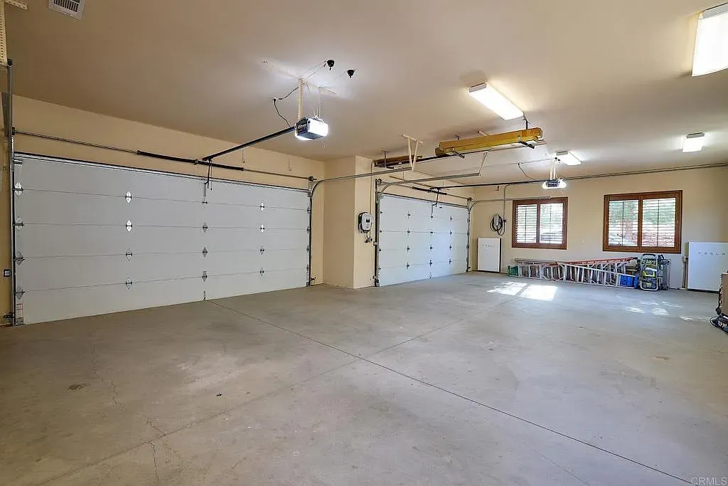 Huge garage with bright lights and a whole wall of storage cabinets.