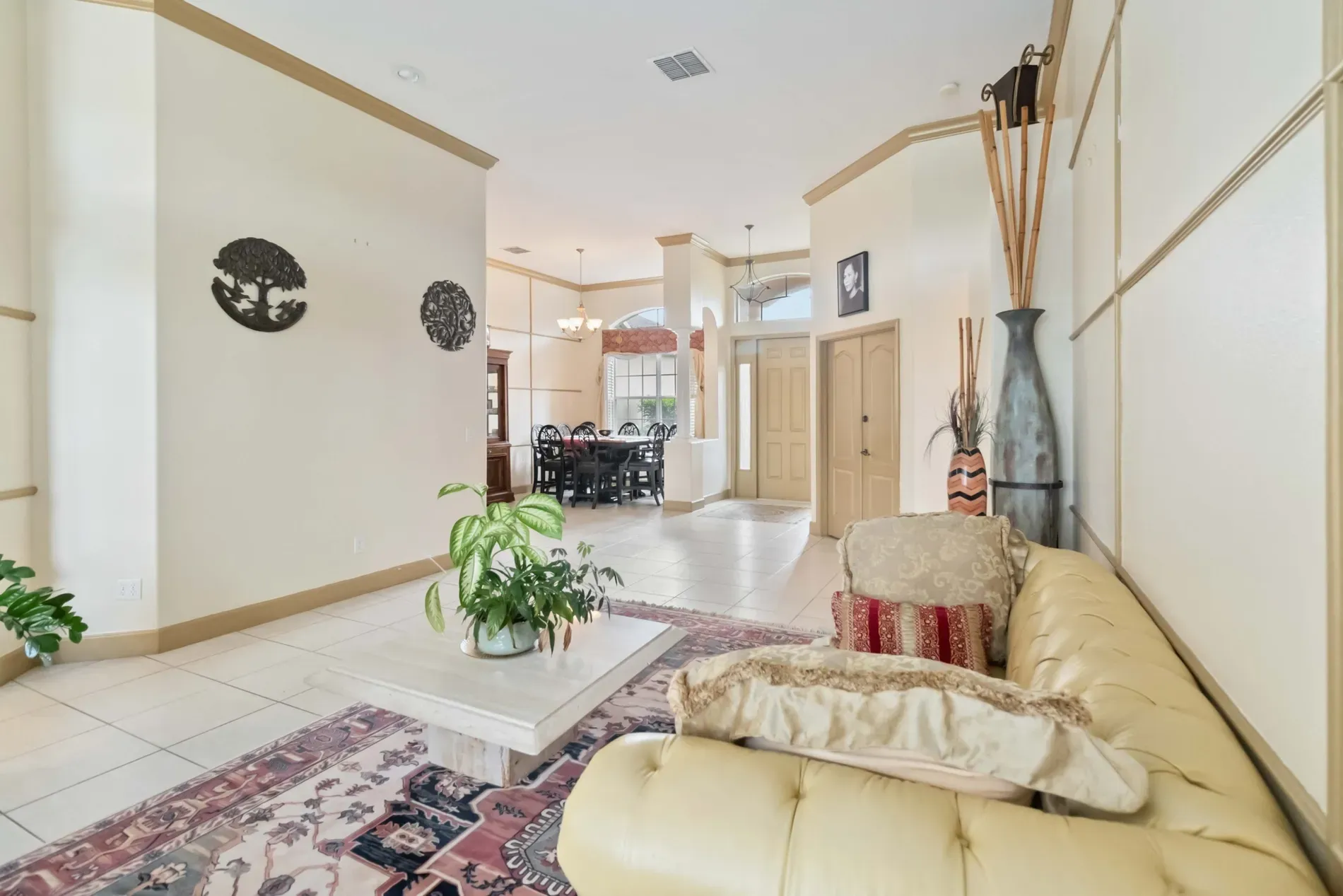 Soft beige walls, cream tile. Spacious, bright. That tufted piece. couch? ottoman?