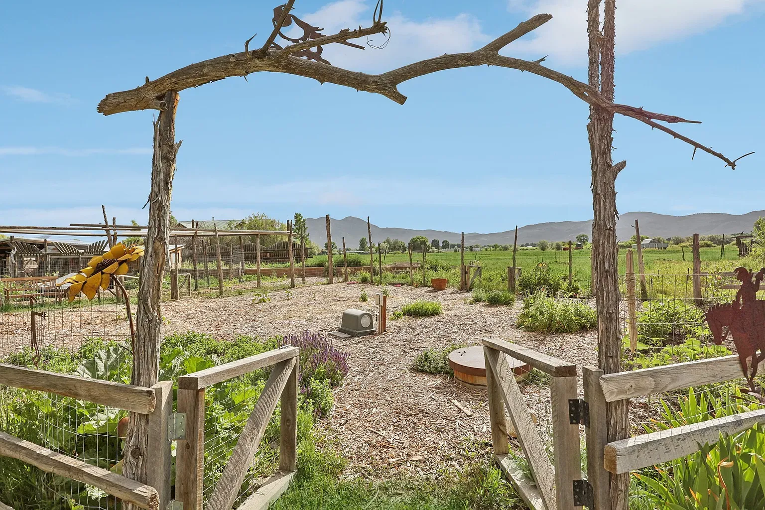 Rustic branch arch into the garden. Feels a little portal.