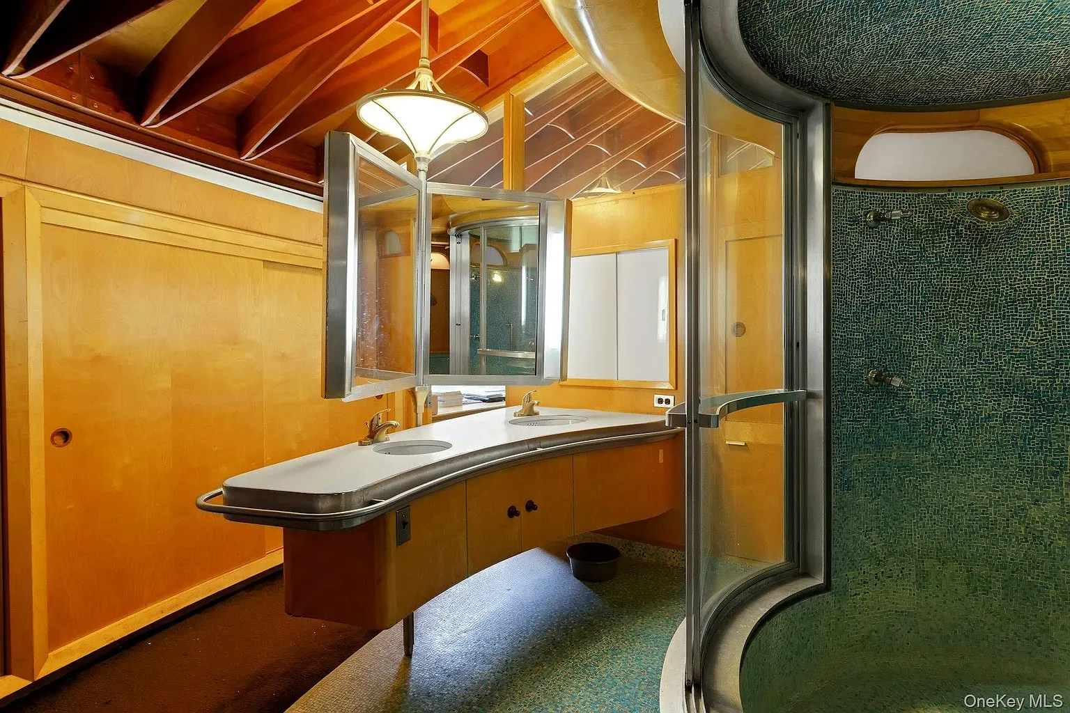 Soft wood bathroom with rounded cabinets. Mid-century-ish without feeling theme-y.