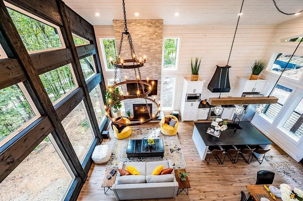 Open great room, huge chandelier, floor-to-ceiling windows. Feels grand but still cozy.