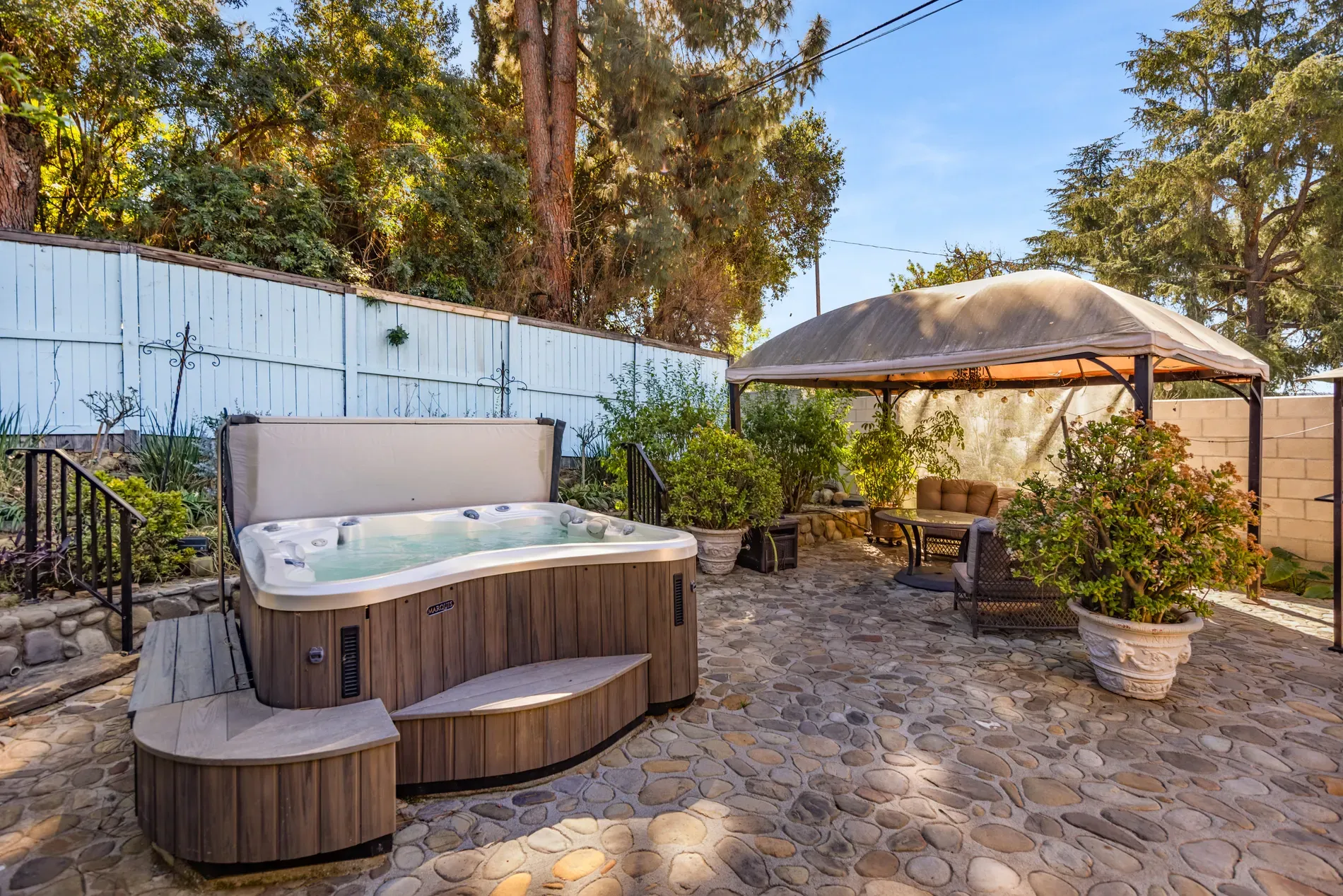 Wood-wrapped hot tub with built-in seats. Backyard spa night unlocked.
