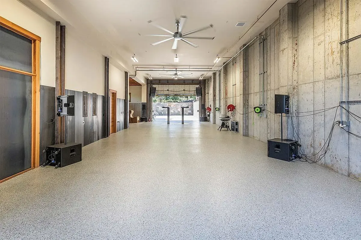 Big, clean workshop with polished concrete and metal walls. Car projects live here.