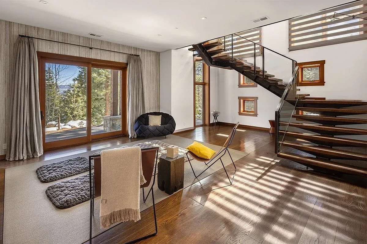 The living room has warm hardwood and that circular black chair stealing attention.
