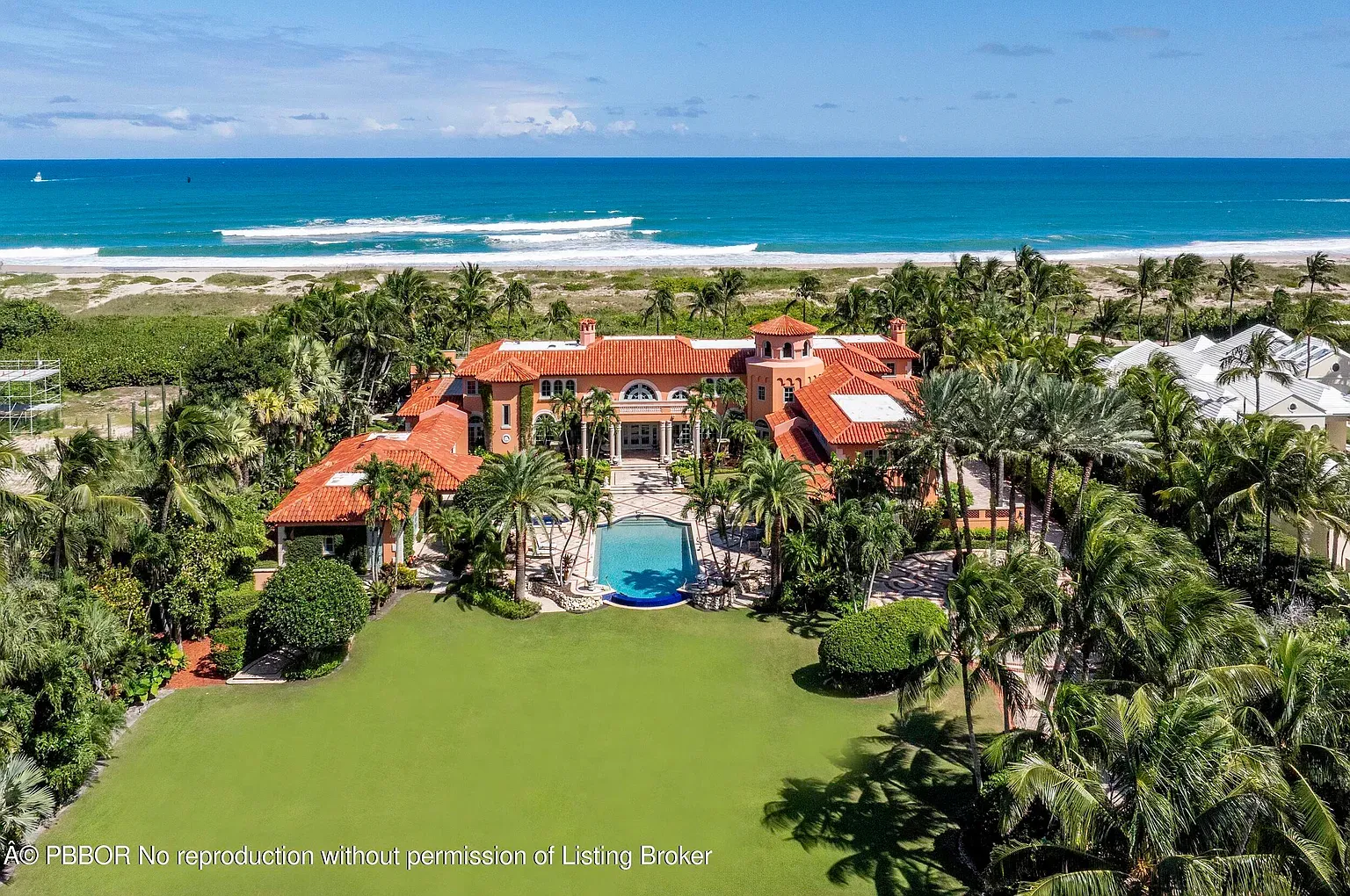Big Mediterranean mansion with terracotta roof and a ton of palms.