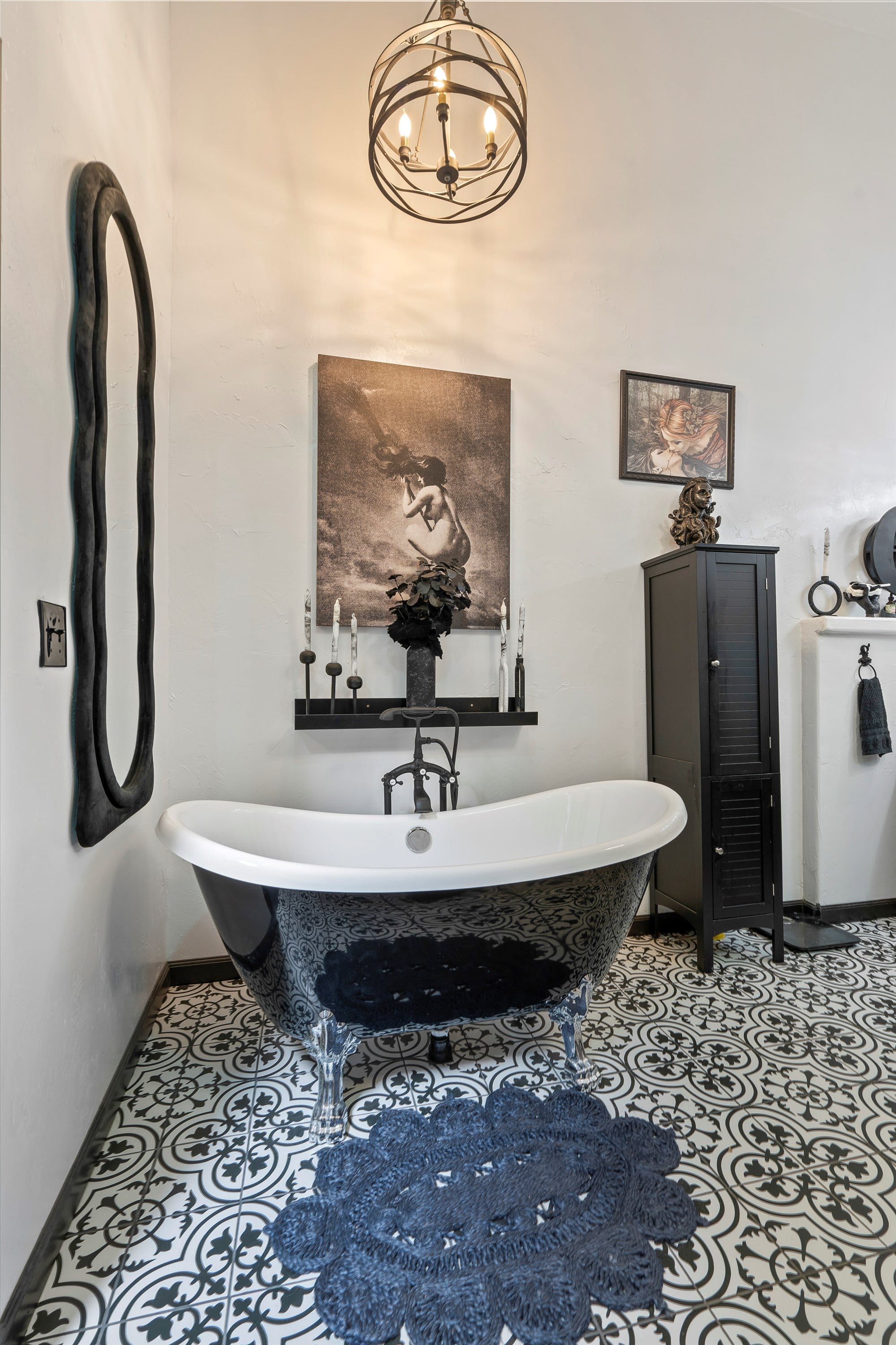 Clawfoot tub in black and white on patterned tile. Classic but bold.