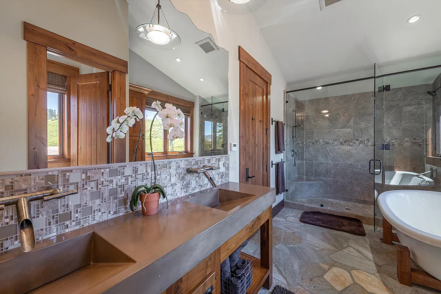 Double vanity with bronze sinks. That mosaic backsplash is carrying the whole mood.