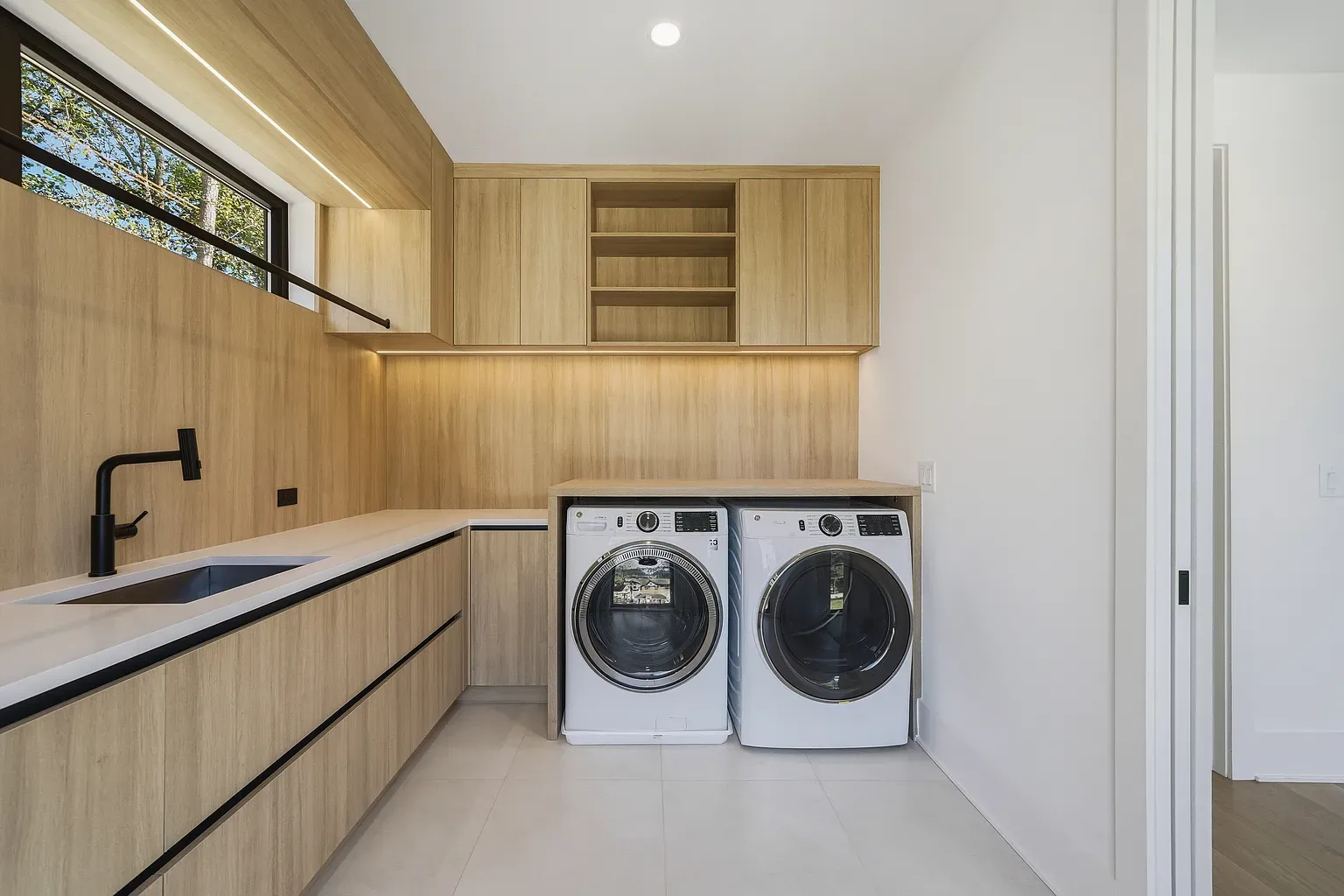 Laundry room you could actually enjoy. Light wood, open shelves, everything reachable.