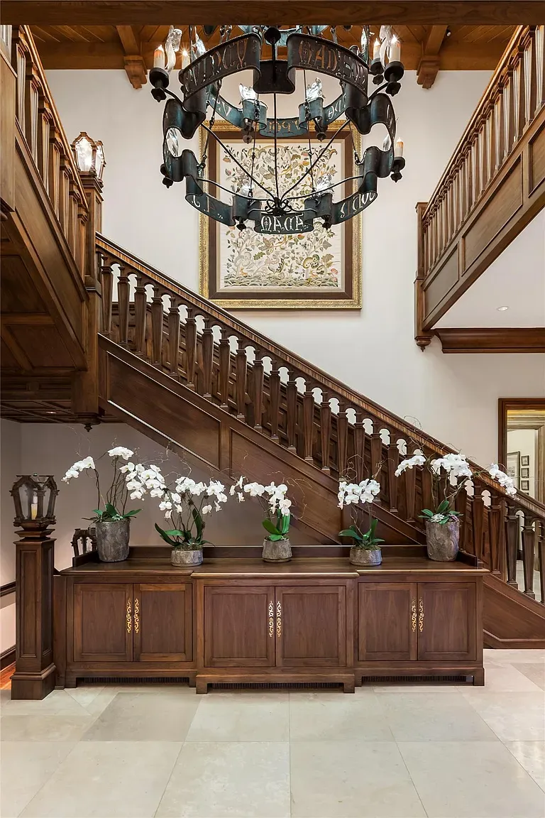 Double staircase moment. Iron chandelier and lots of wood, feels very formal.