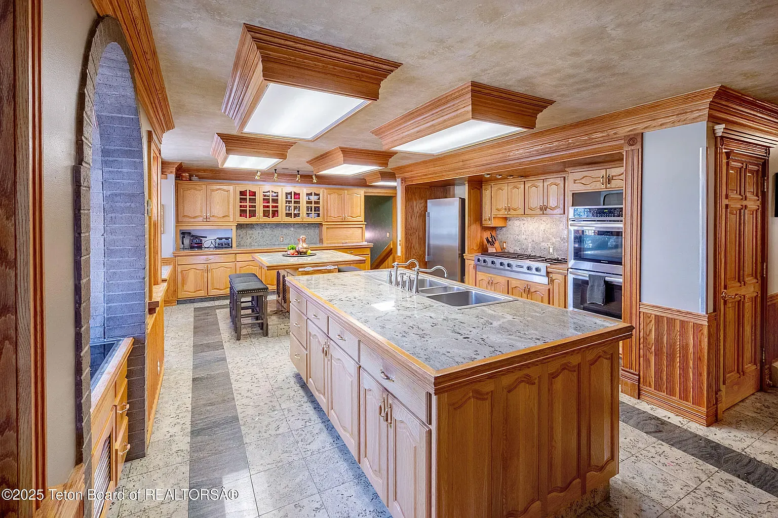 Honey cabinets, big island, classic moldings. Not trendy, just solid and warm.