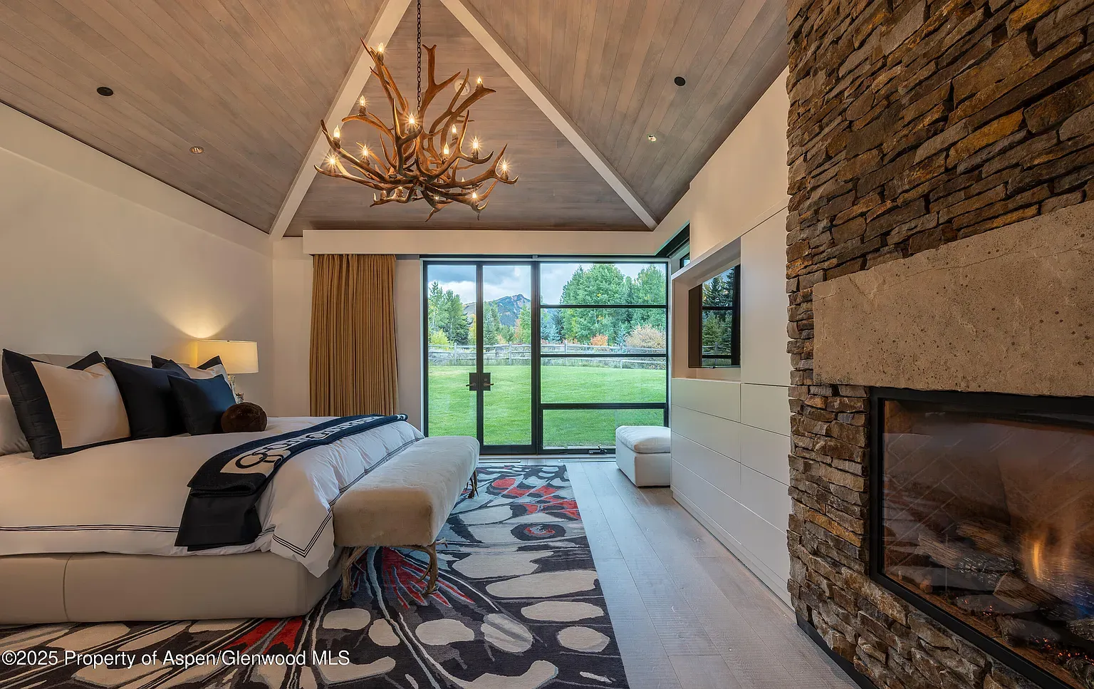 Vaulted wood ceiling over the calmest bedroom. Crisp bed, mountain lodge energy.