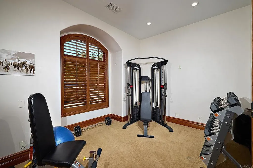Gym with a big arched window and shutters. Sunlight makes burpees slightly nicer.