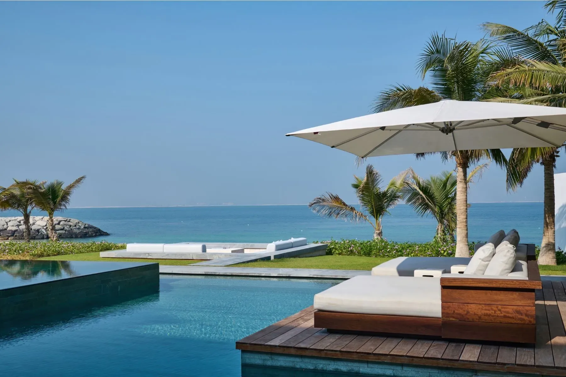 Infinity pool just melts into the sea. Landscaping is doing the most.