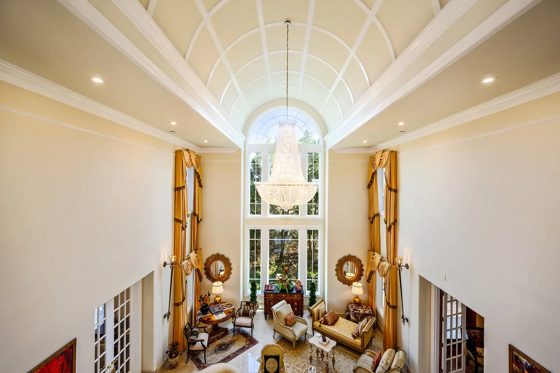 Okay, this great room—double-height coffered ceiling, chandelier looks massive from here.