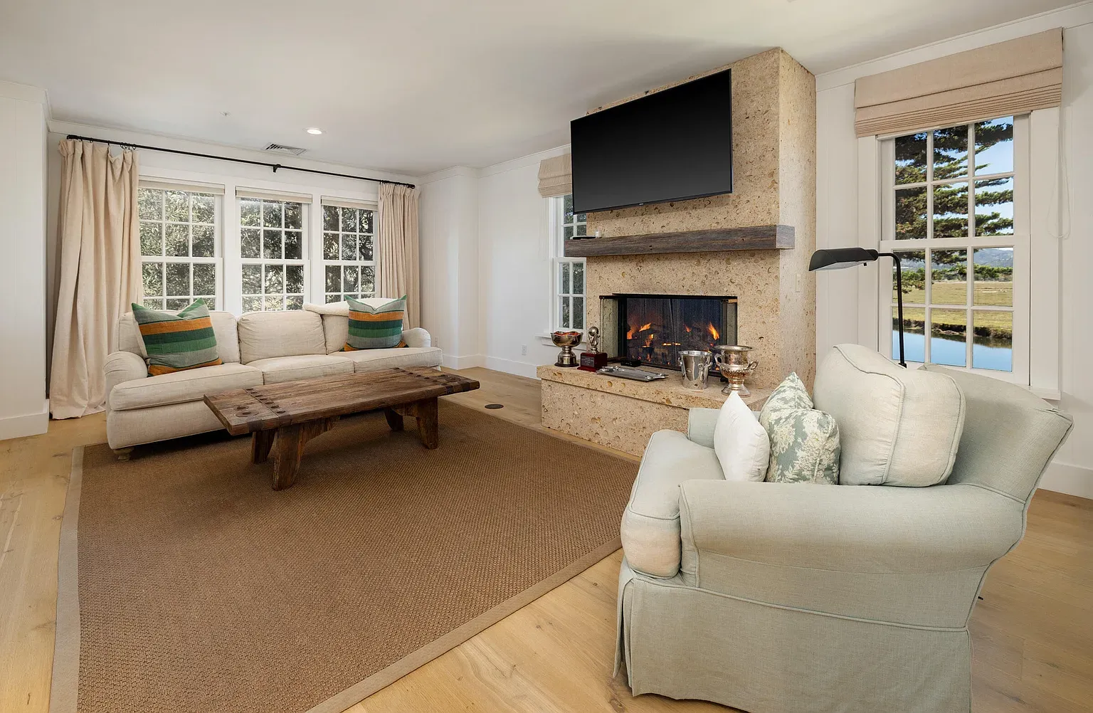Stone fireplace with a clean wood mantel and the inevitable TV. Cozy anyway.