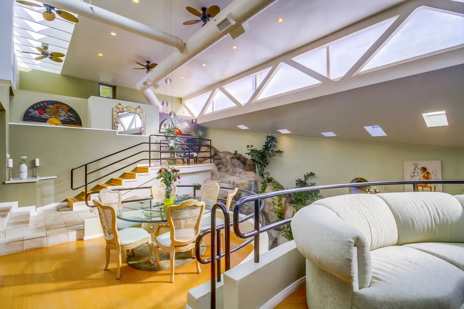 Round glass table with rattan chairs. Very breezy, almost resort dining vibes.