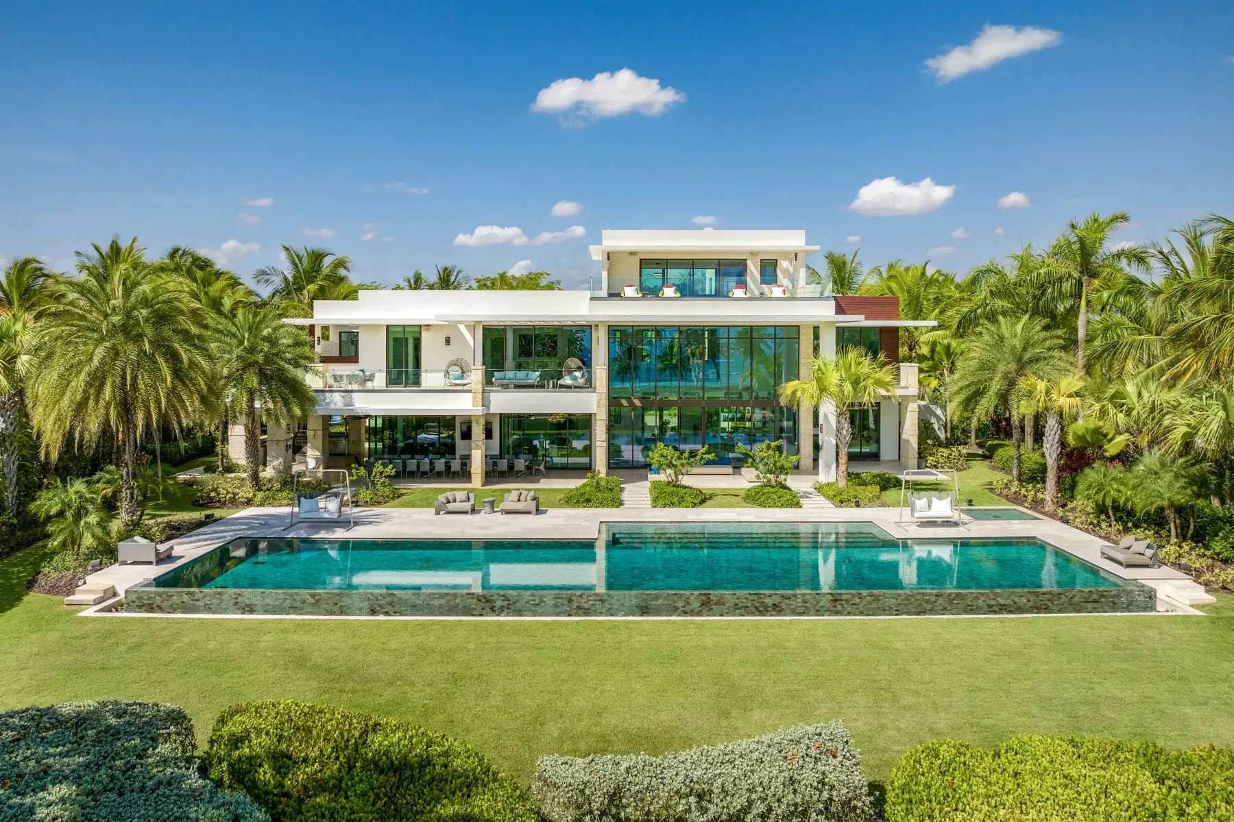 Tropical glass box vibes. three levels tucked into palms.
