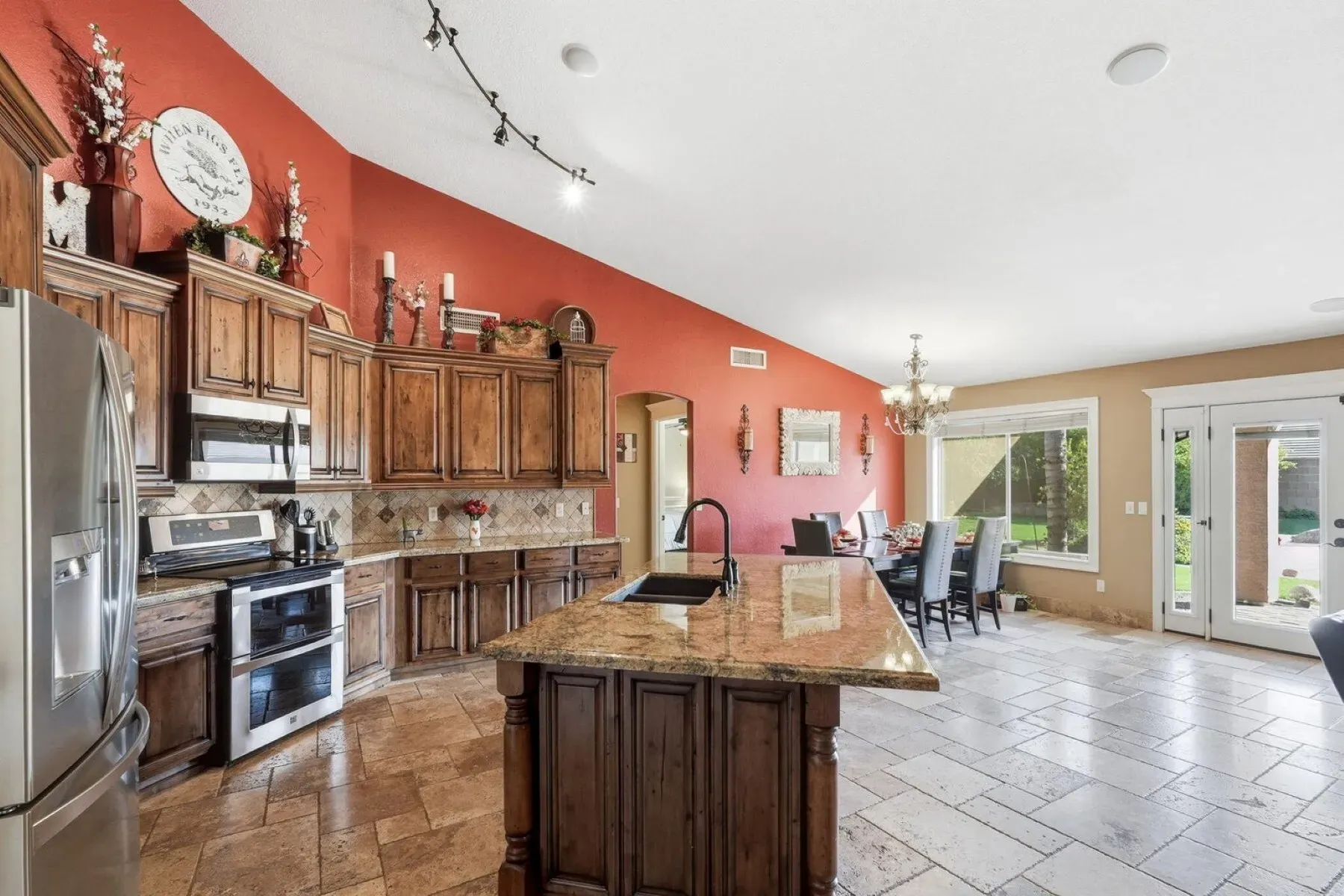 Deep mocha cabinets plus a red wall—warm, classic kitchen vibes.