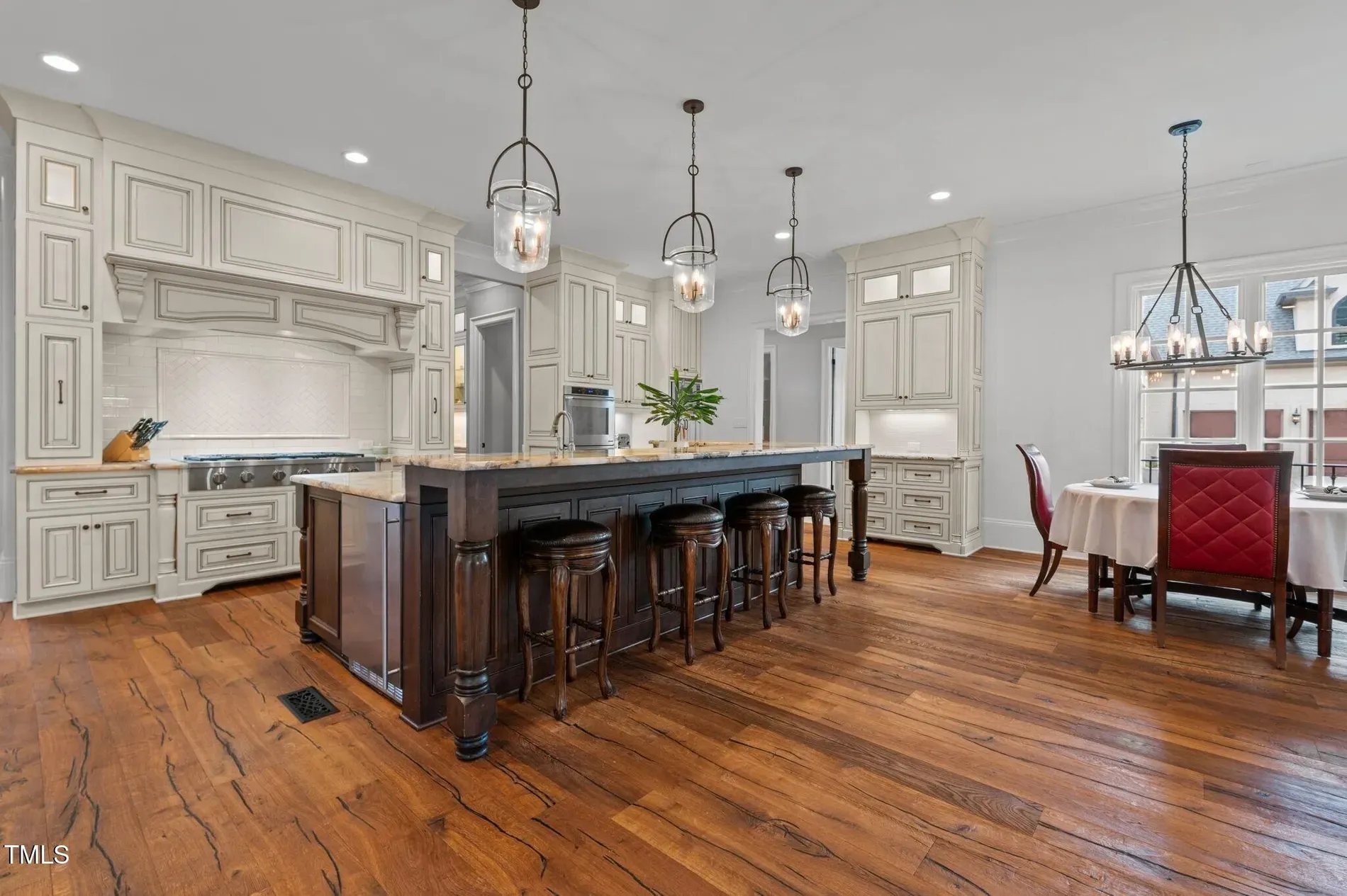 Kitchen island’s a unit. Dark wood vs creamy cabinets—classic combo.