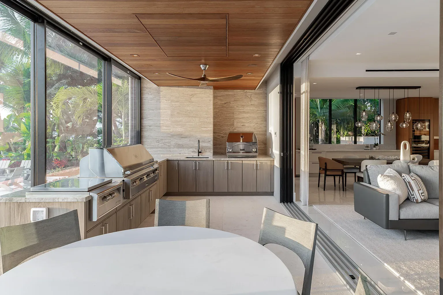 Outdoor kitchen goals. Big sliders, breezy tiles, and all the plants thriving.