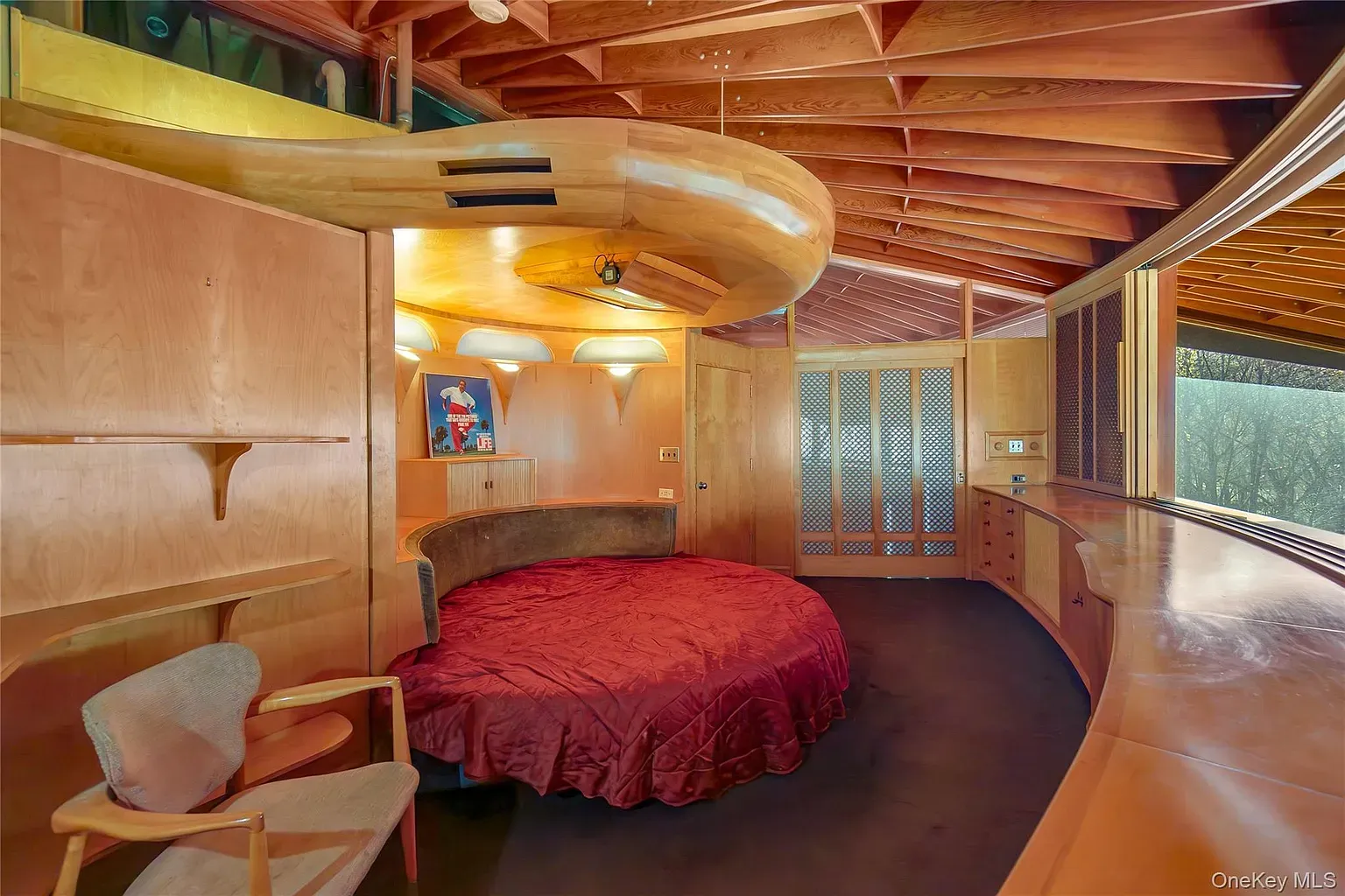 Cozy cocoon bedroom. The red duvet pops against all that wood.