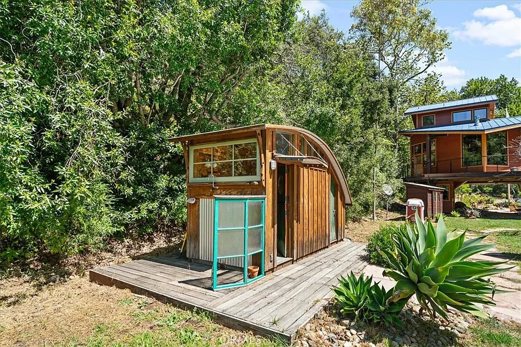 Arched-roof outbuilding? Looks handcrafted and super charming with those big windows.