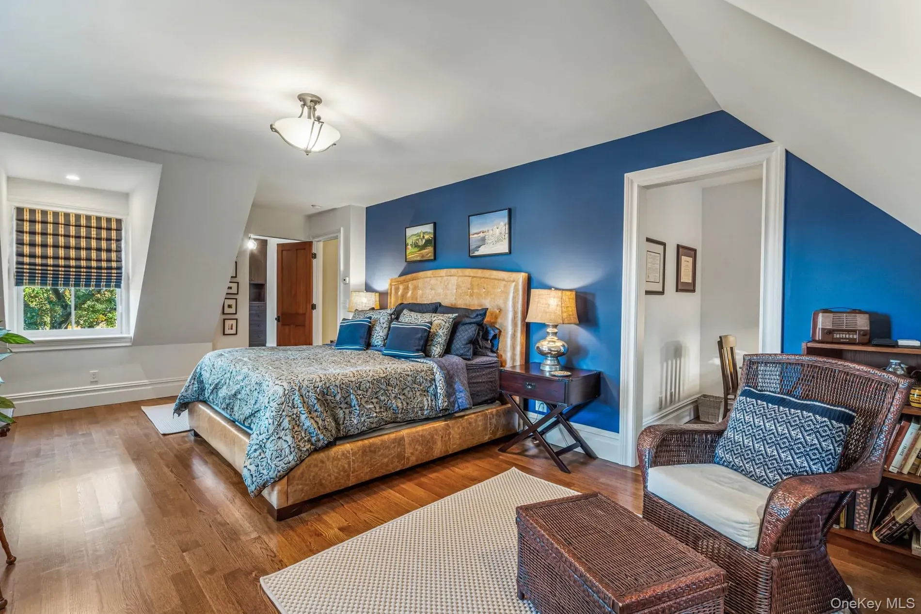 Sloped-ceiling bedroom. big bed with that blue-and-gold comforter stealing the show.