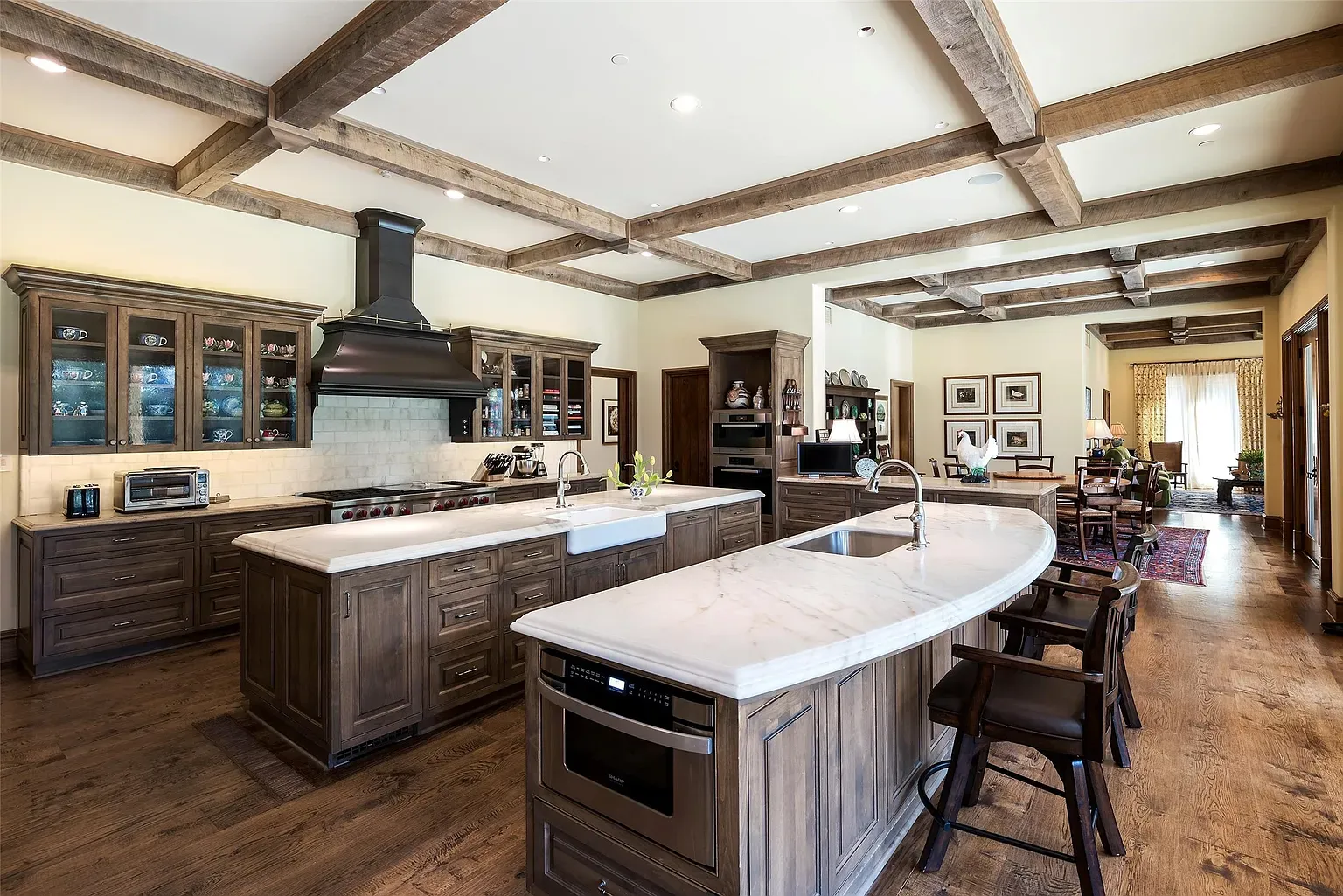 Big kitchen, dark beams, glass-front cabinets. Feels it smells bread.