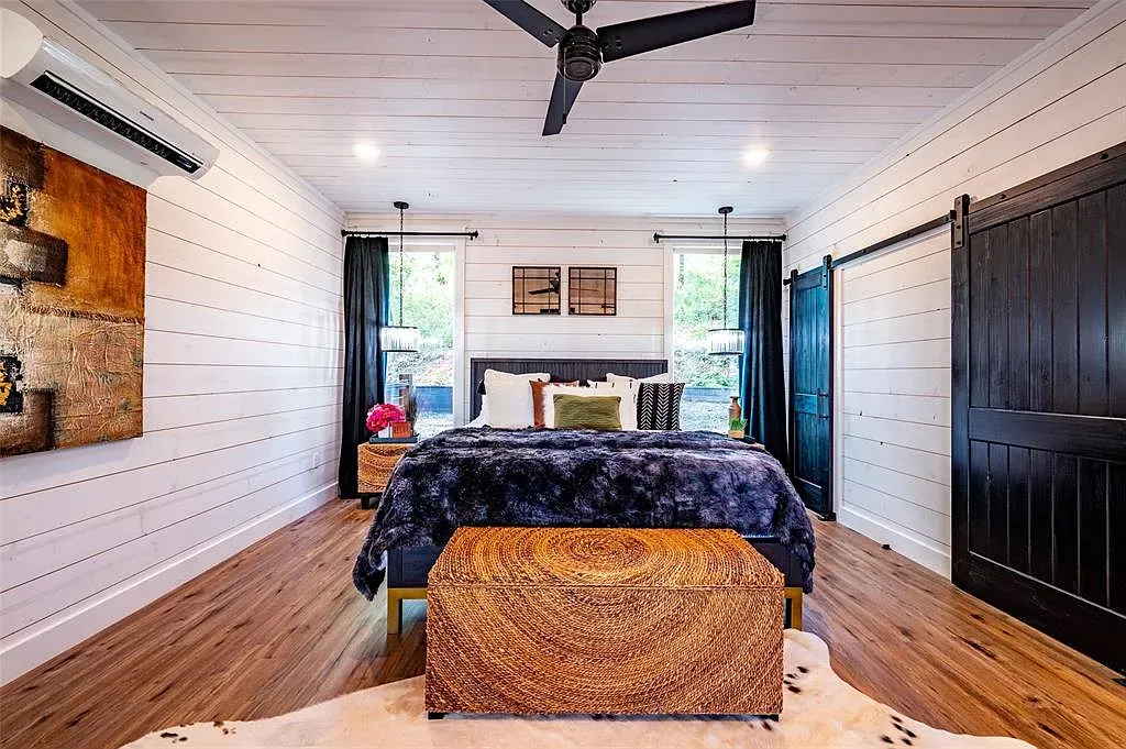 Bedroom stays calm. white paneling, wood floors, giant bed that begs for naps.