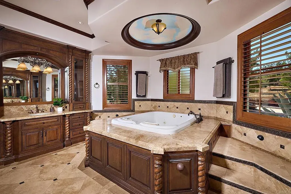 Spa bathroom feeling. ornate wood vanity, stone, and a tub that wants attention.