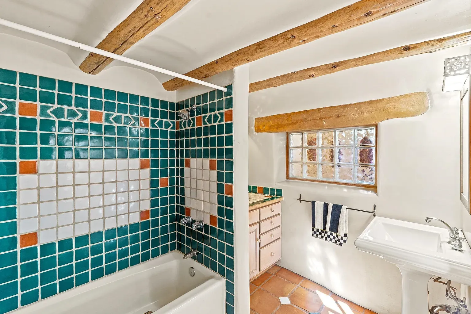 Turquoise tiles go full geometric. Terracotta details keep it cozy.