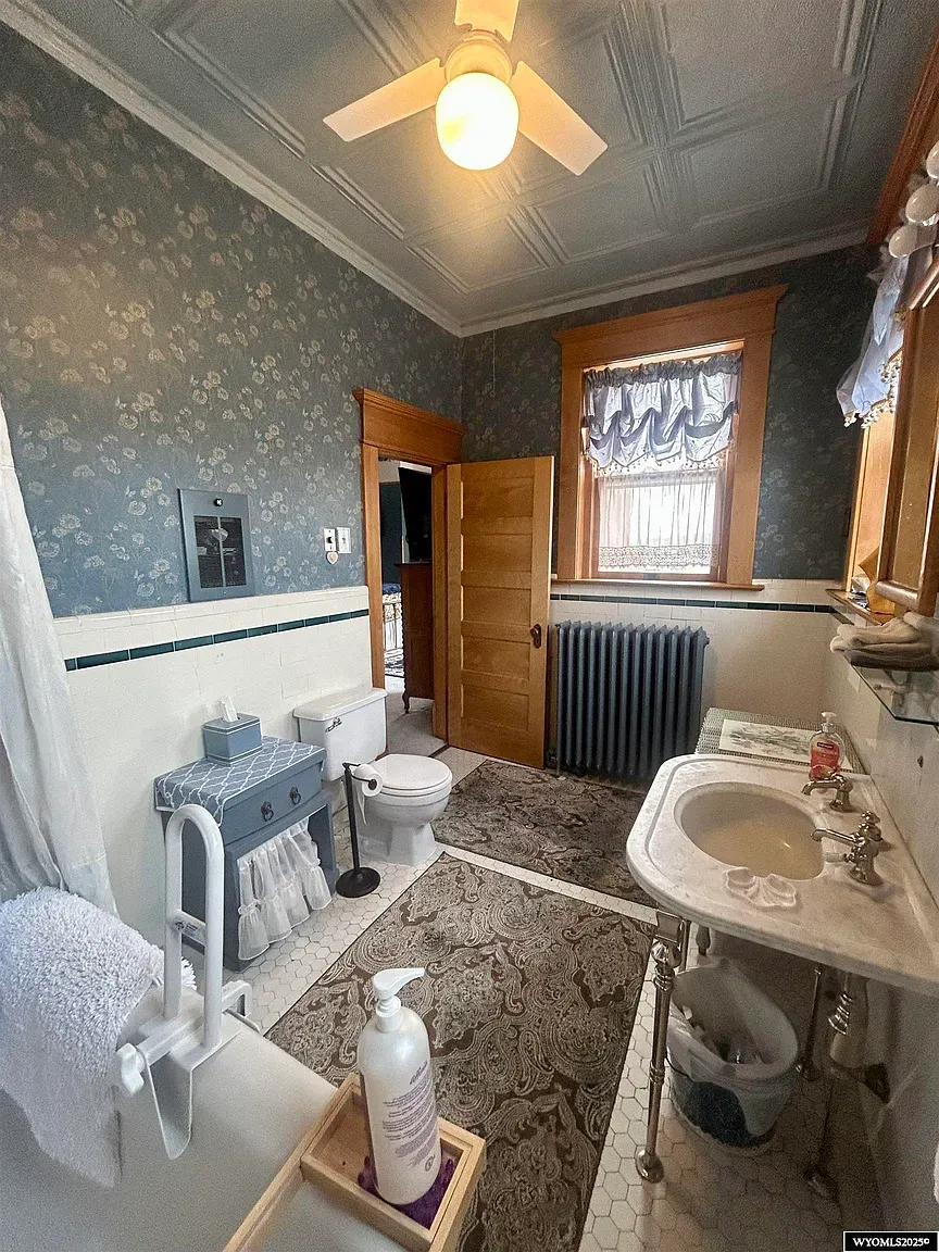 Floral wallpaper and crown molding in the bathroom. Vintage without feeling fussy.