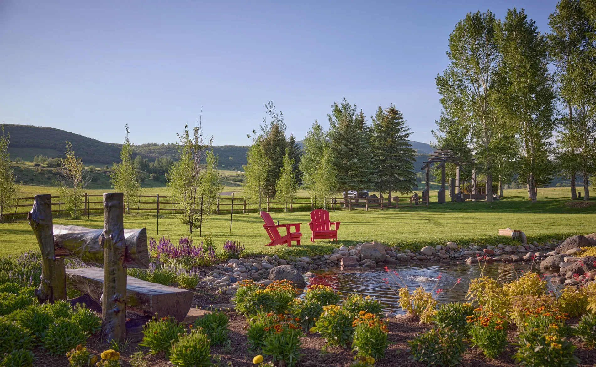Back outside, a calm pond with flowers and soft hills. Postcard vibes.